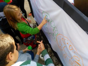 Los niños colorean con sus dedos el logo de AS en San Gerardo.